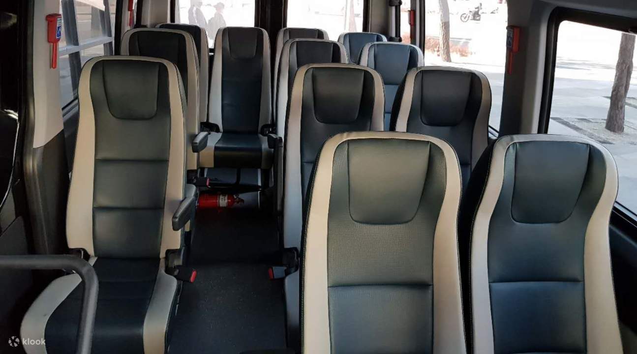 Reisebusinnenraum mit schwarzen Sitzen und weißem Futter